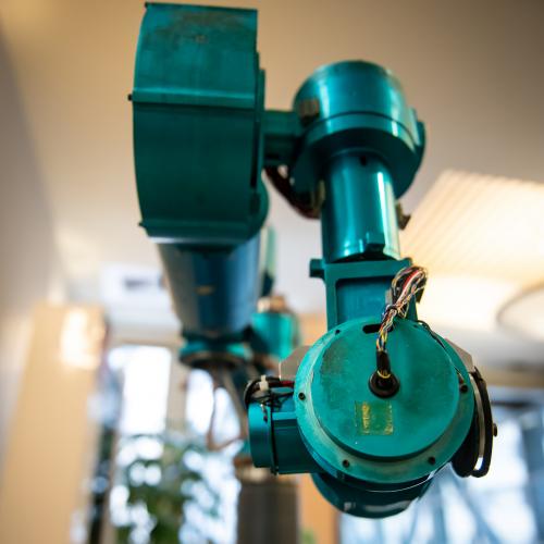 A close-up image of a blue robotic arm with multiple joints