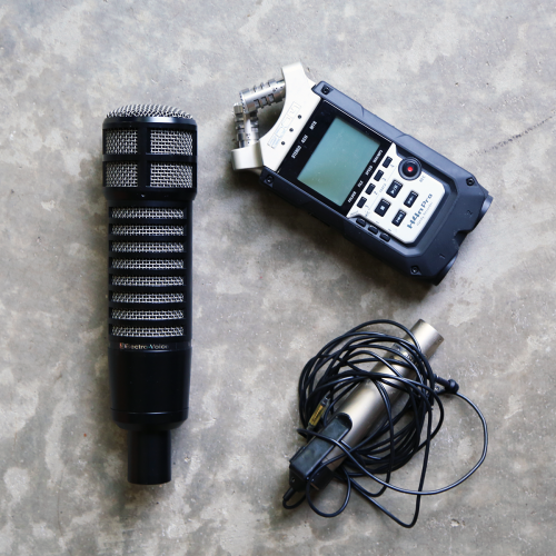 An image of two microphones and a digital recorder displayed on a table.